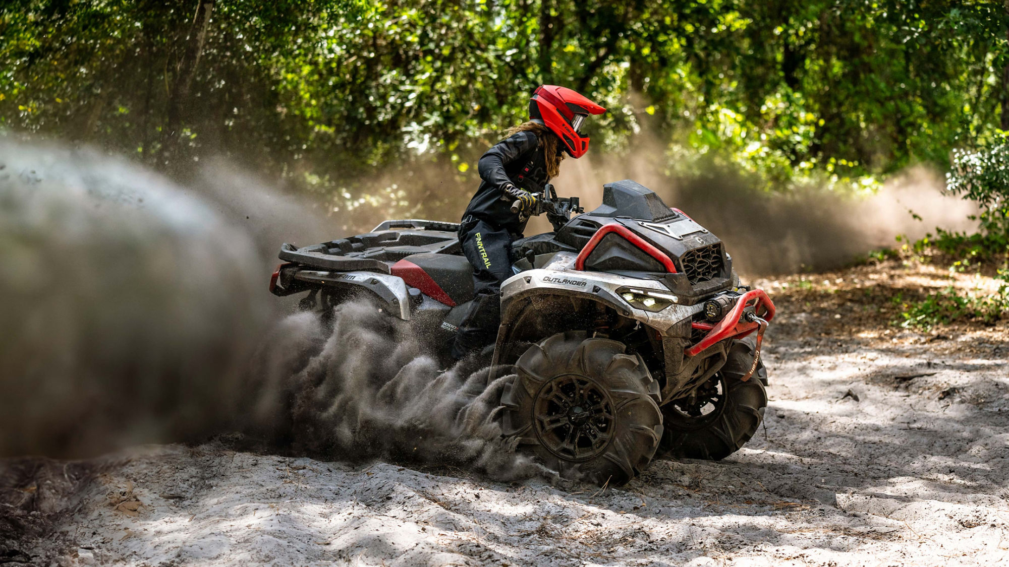 The Can-Am Outlander X MR 1000 2025 creating dust while rolling in the sand