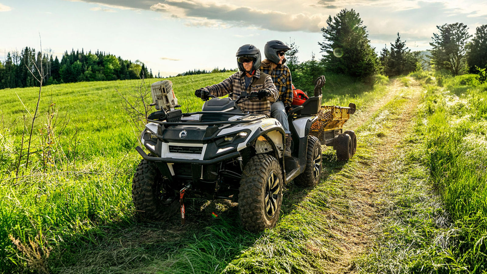 Two ranchers on a Can-Am Outlander electric ATV pulling loads