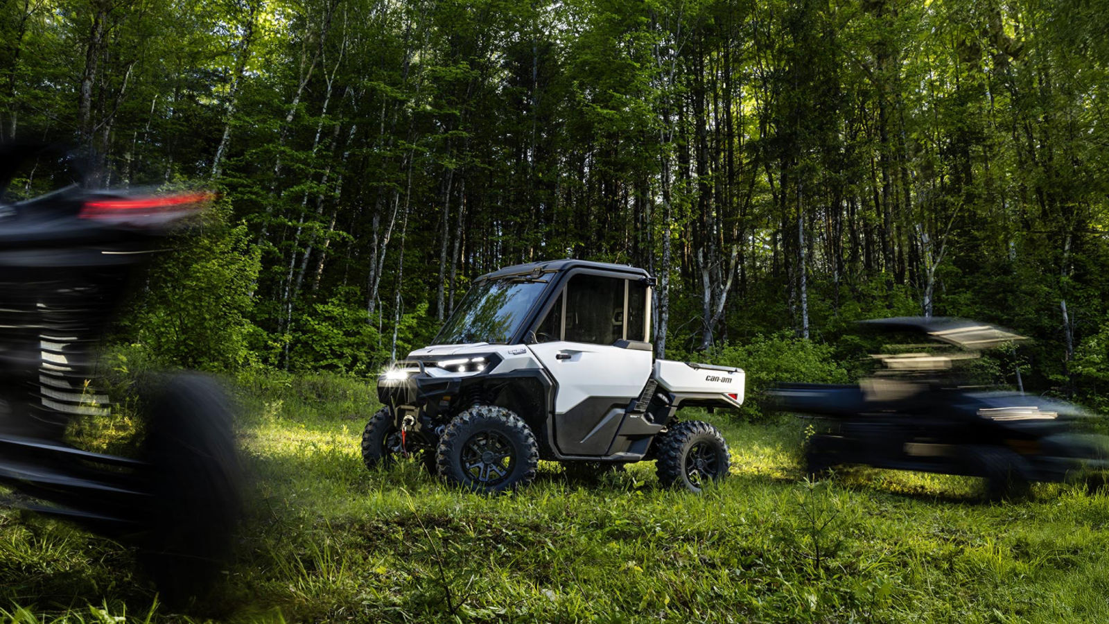 A 2026 Can-Am Defender HD11 hybrid white side-by-side vehicle in the fores