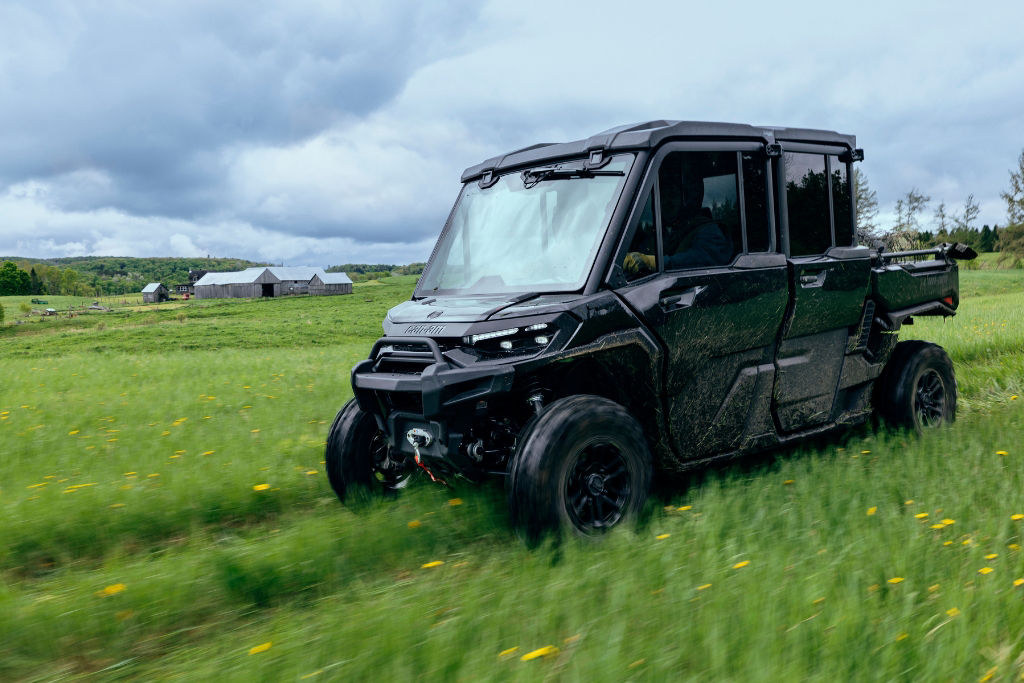 Can-Am Defender driving through a paddock