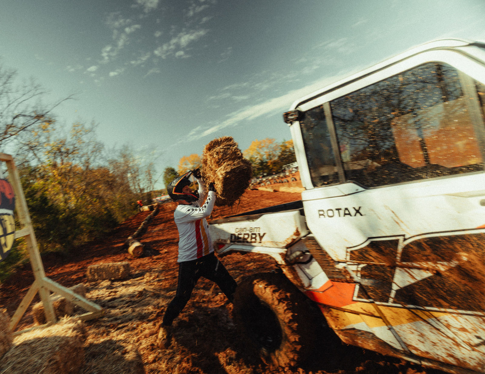 A driver placing hay in the trunk of a Can-Am Defender HD11 during the Can-Am Derby
