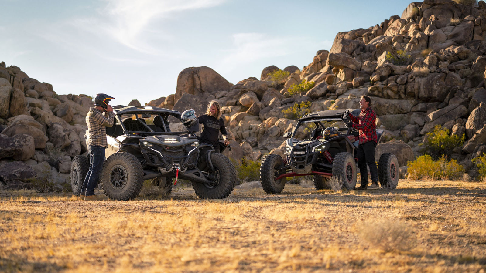 Several Can-Am Maverick side-by-side vehicles driving in the desert