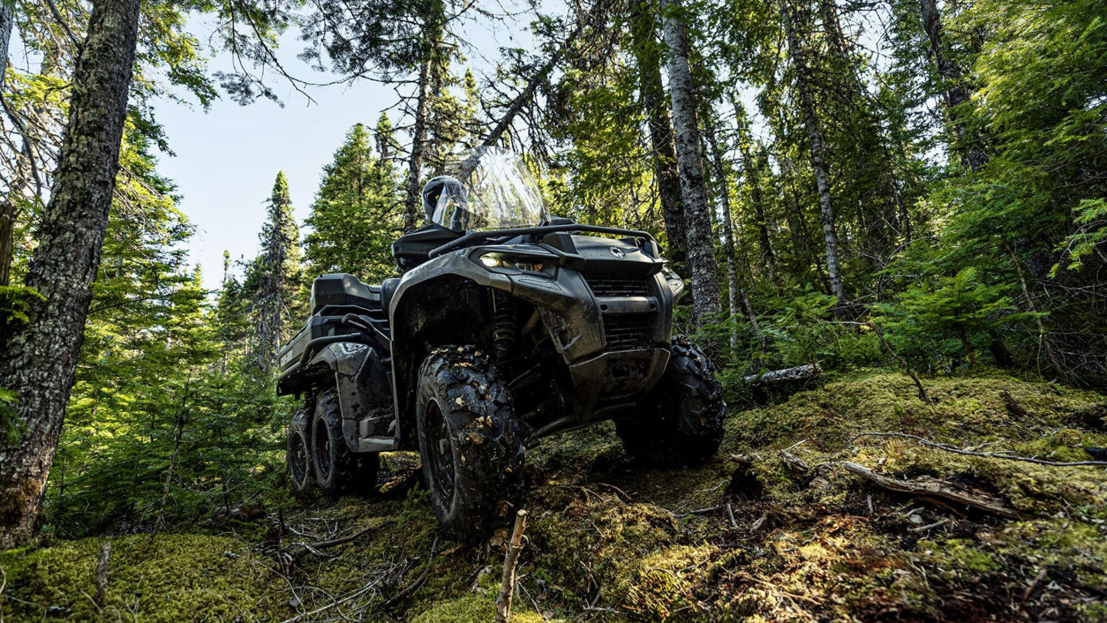 2026 Can-Am Outlander 6x6 ATV passing over rocks and obstacle