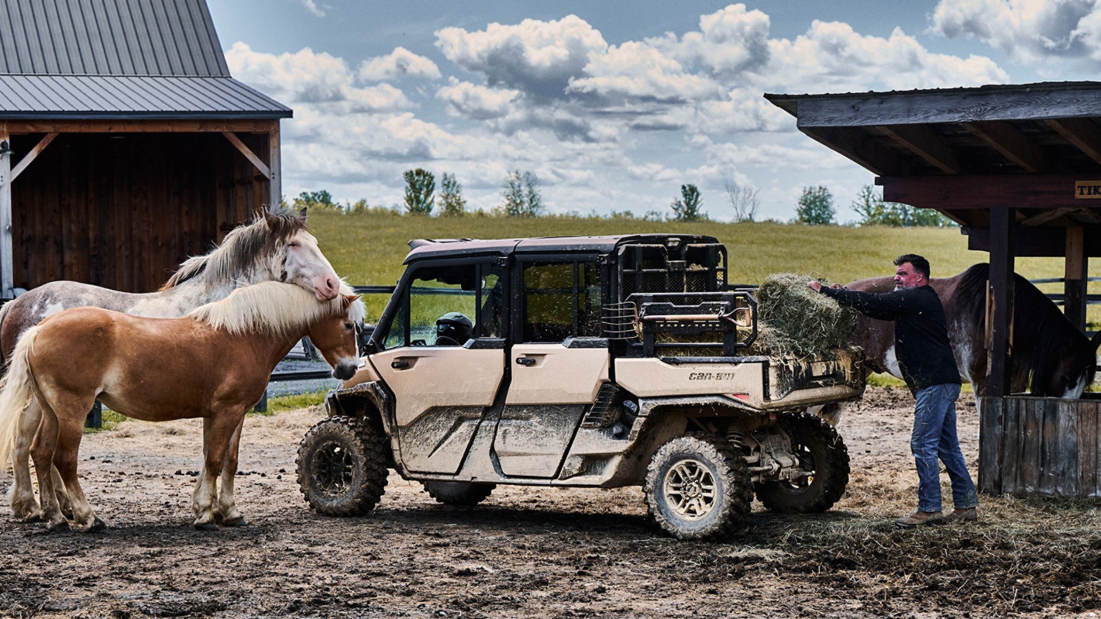 Un agricultor cargando heno en la caja de su Can-Am Defender 2027 en un rancho, rodeado de caballos