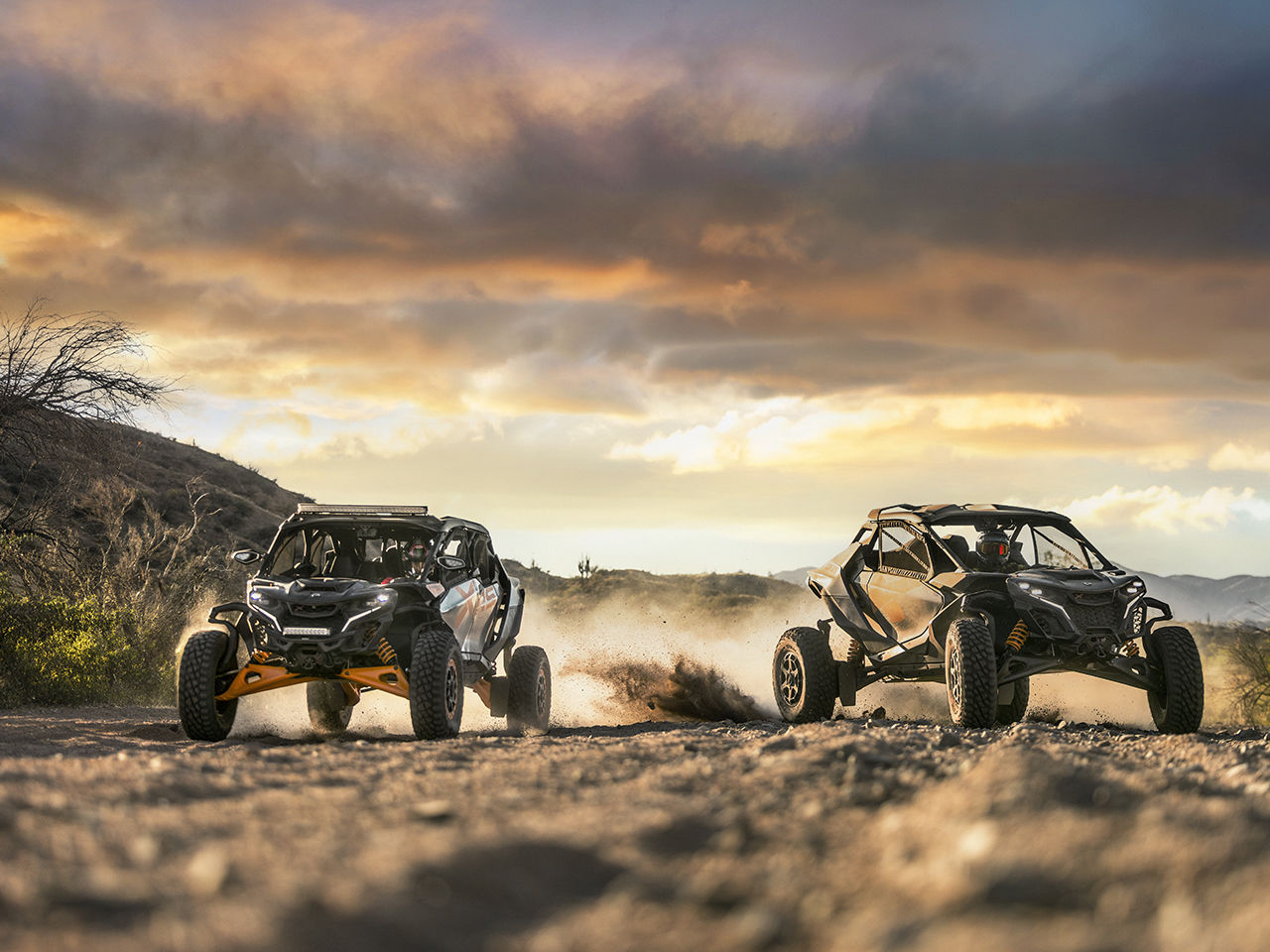 Dos vehículos side-by-side Can-Am Maverick circulando por el desierto al atardecer