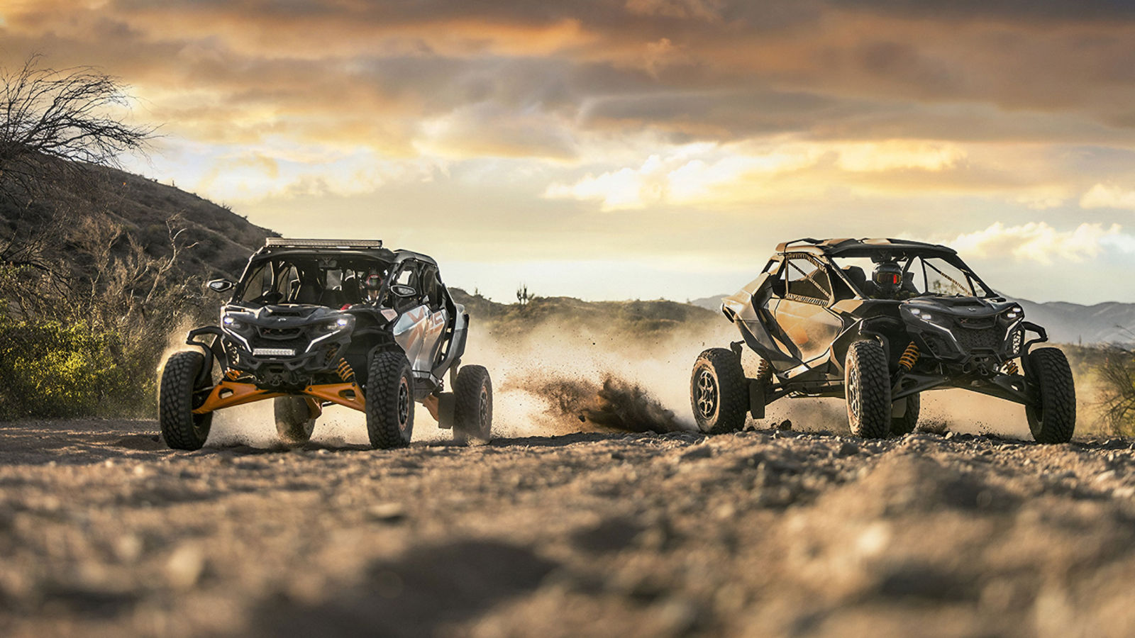 Dos vehículos side-by-side Can-Am Maverick circulando por el desierto al atardecer