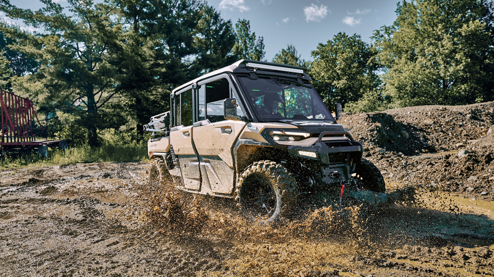2027 Can-Am Defender XU HD10/HD11 utility side-by-side splashing through off-road mud
