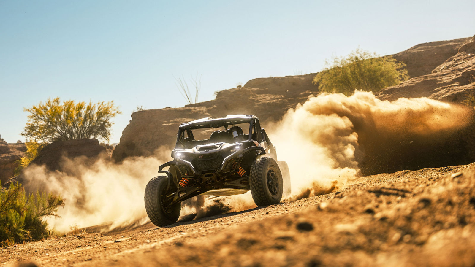 Can-Am Maverick R side-by-side vehicle kicking up dust in the desert