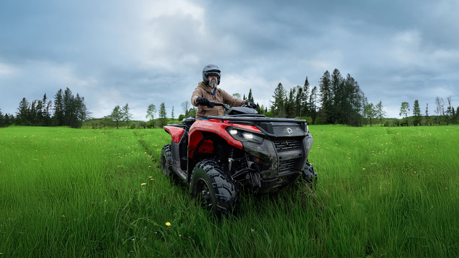 Person riding a Can-Am ATV in a field