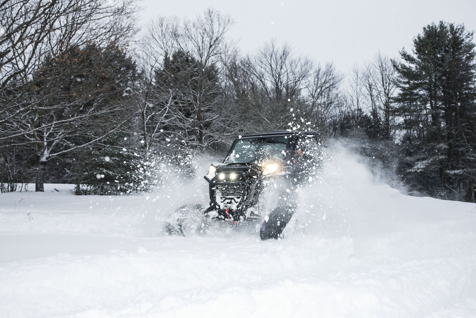 Can-Am SxS vehicle riding through the deep snow with the Apache LT track system