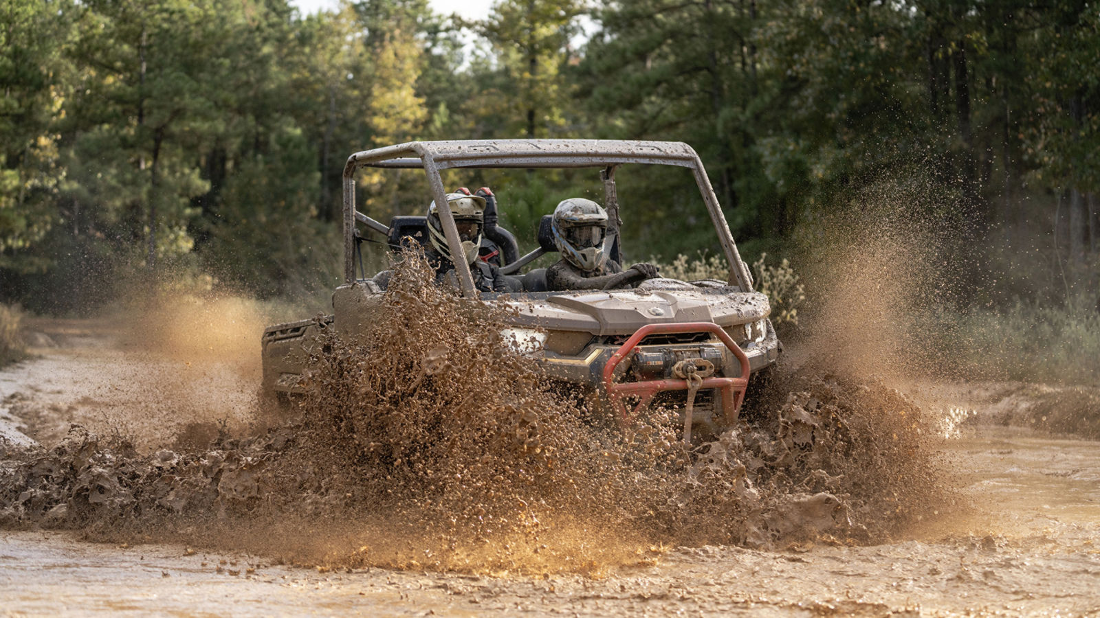 Hombre conduciendo su vehículo a través del barro