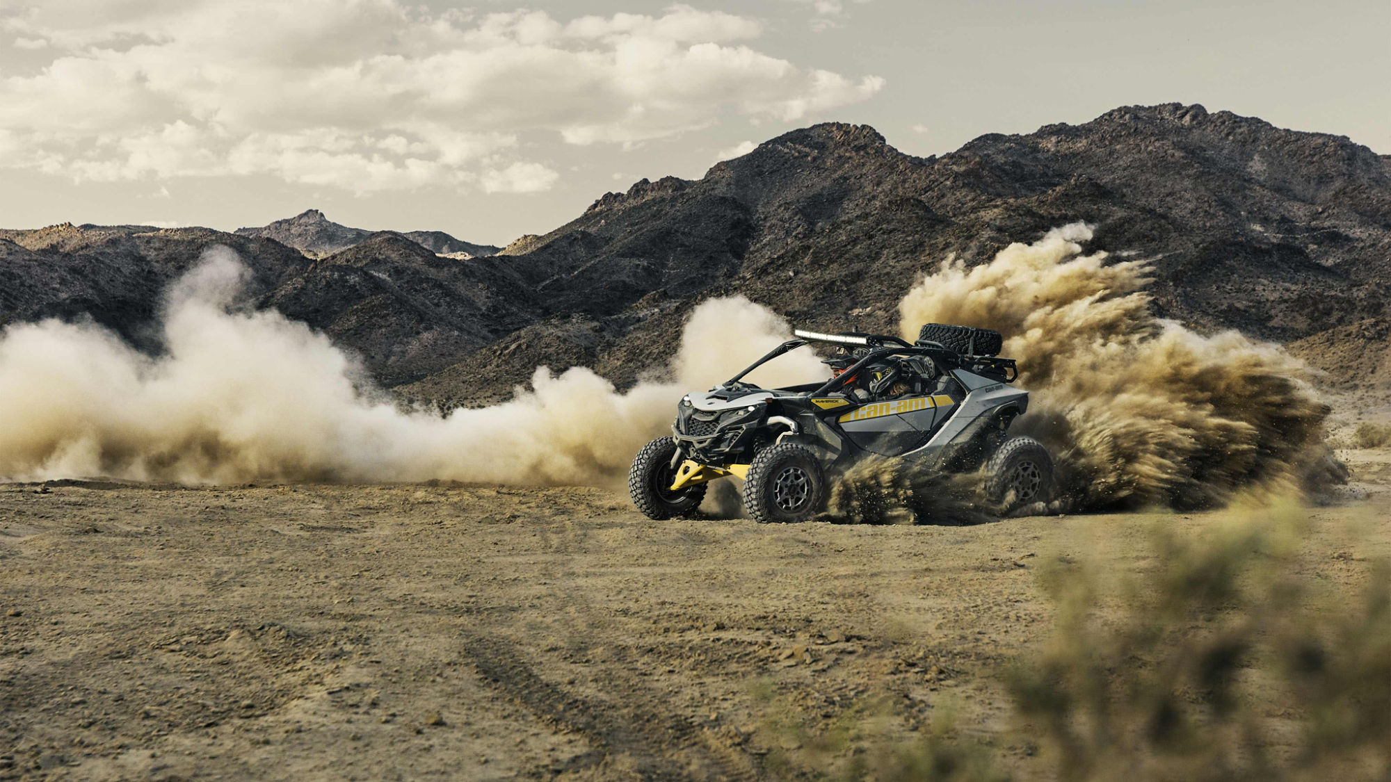 A Can-Am Maverick R 2024 with a 240 HP rotax engine drifting in the sand.