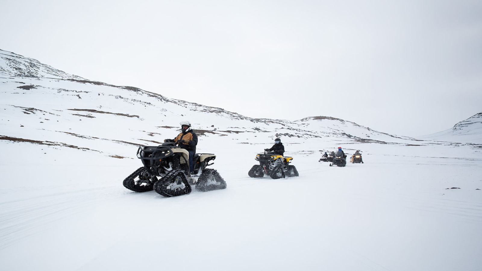 Group of riders on tracked Can-Am ATVs navigating Nunavut