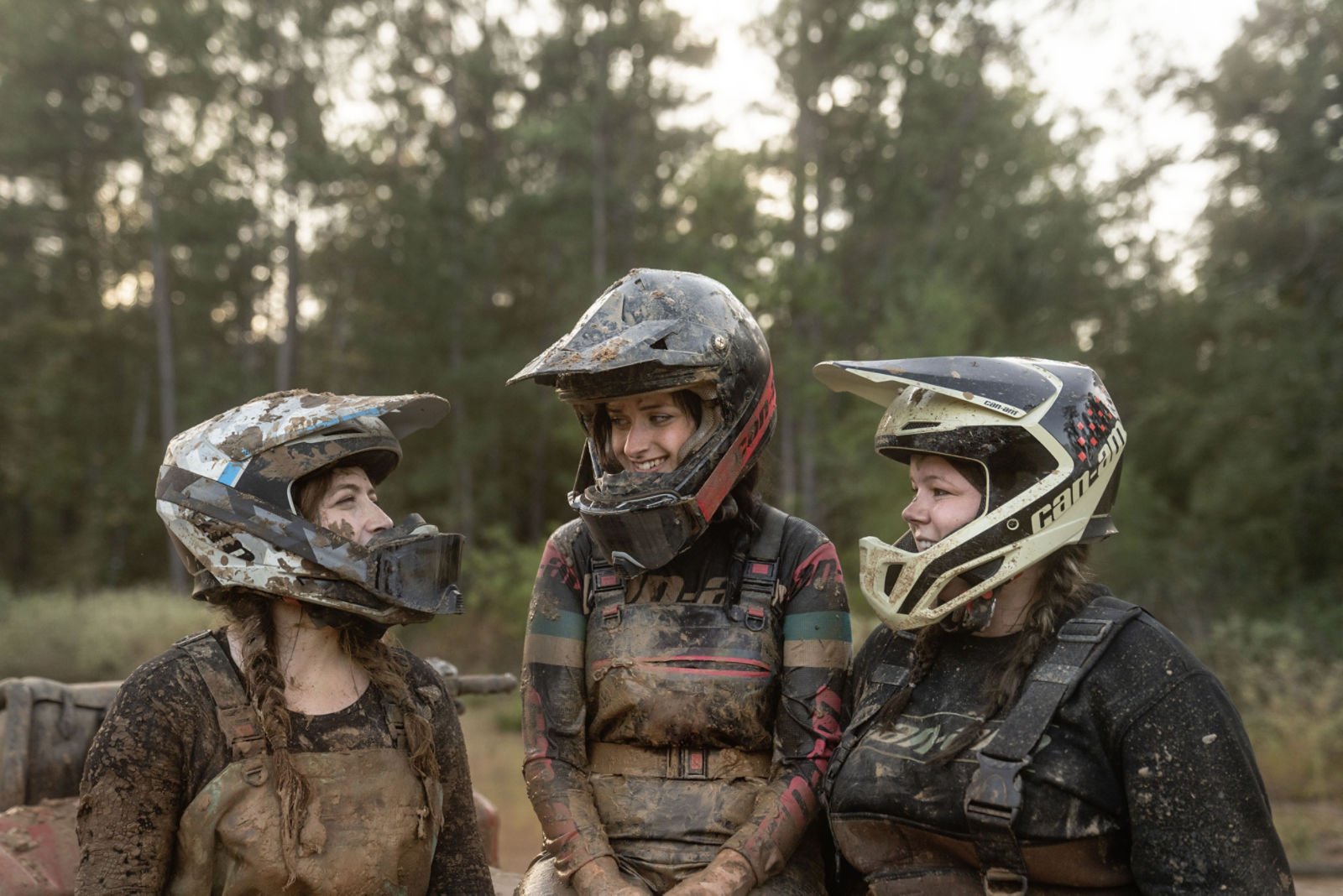 Trois femmes portants de l'équipement Can-Am couvertent de boue