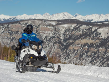 2 personnes sur un Ski-Doo dans les montagnes