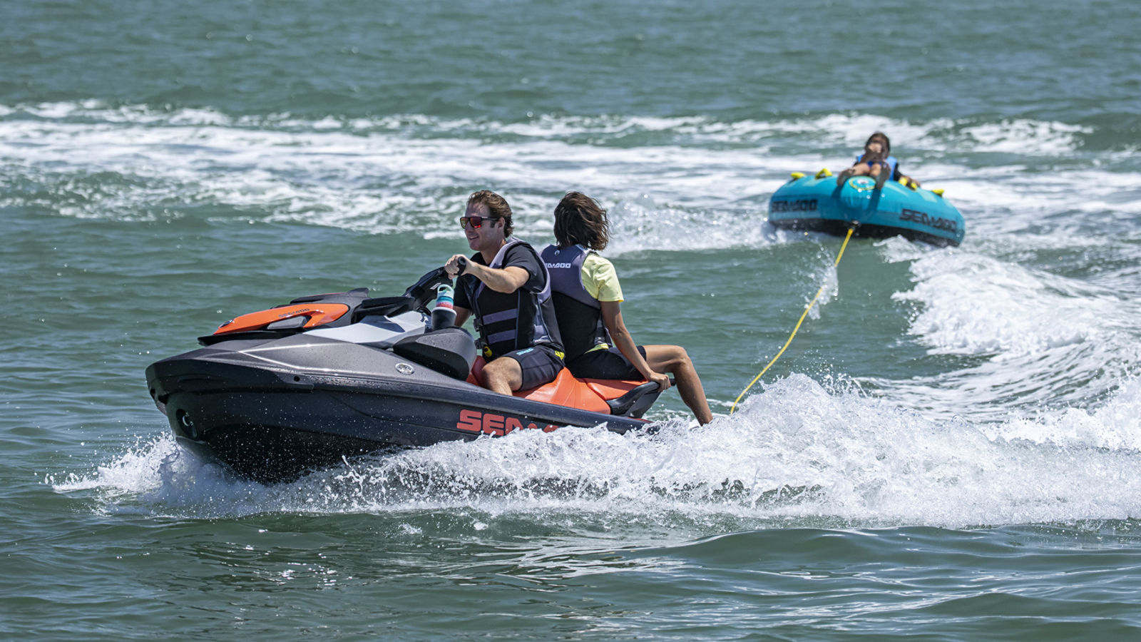 Couple on a Sea-Doo GTI pulling a tube