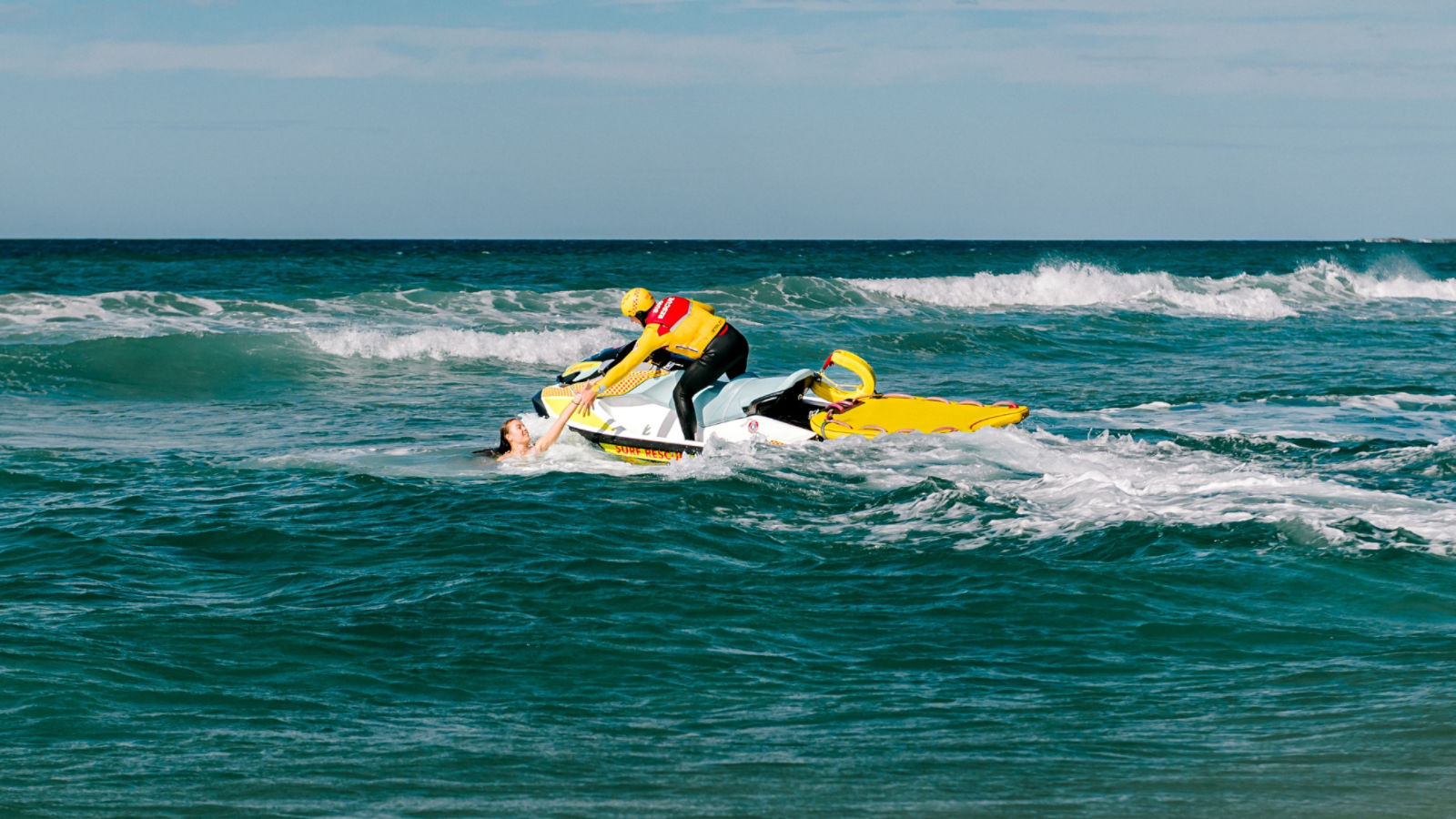 SLSA operator pulling a person from the water