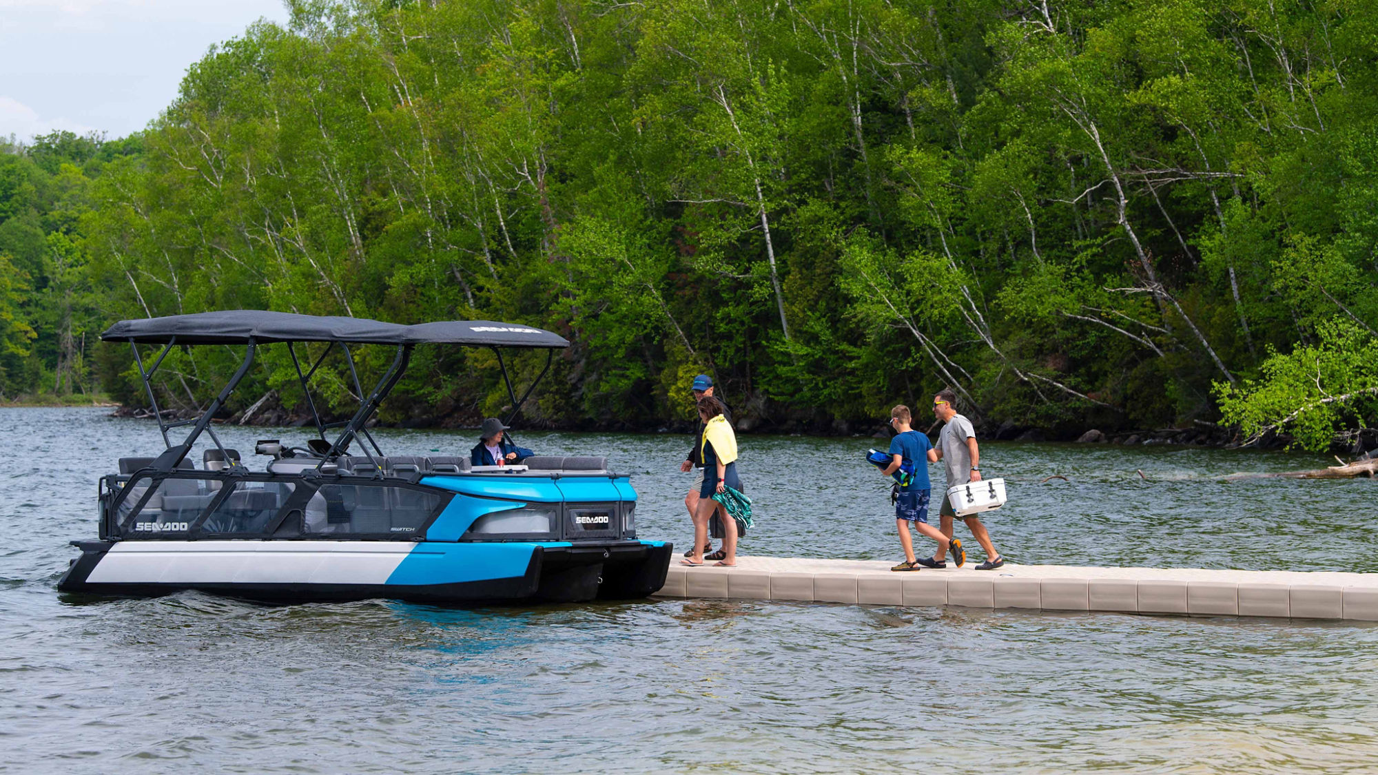 Groupe d'amis marchant sur un quai près d'un Sea-Doo Switch