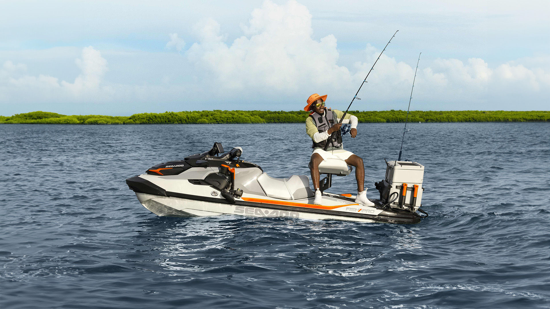 Man reeling in a fish while sitting on his Sea-Doo FishPro Trophy equipped with Sea-Doo accessories