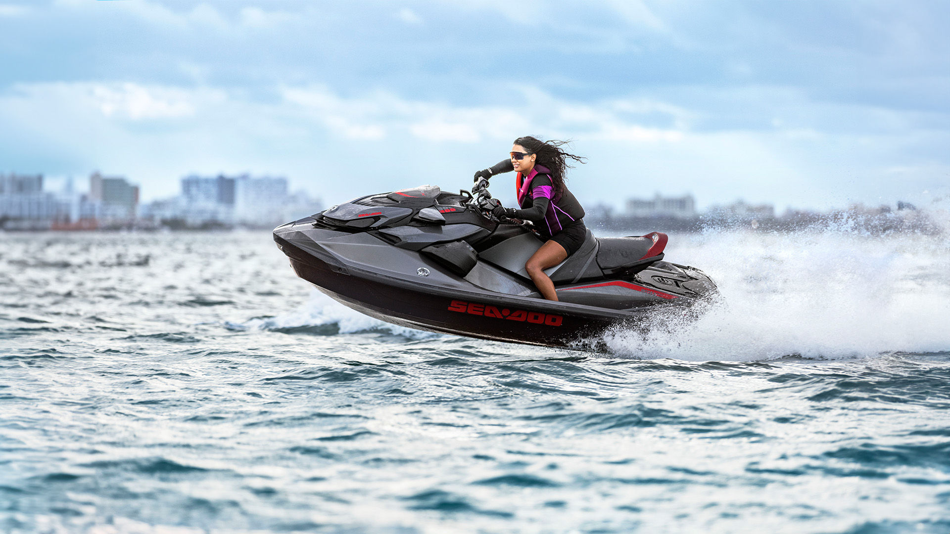 Rider making waves while riding her Sea-Doo PWC at high speed