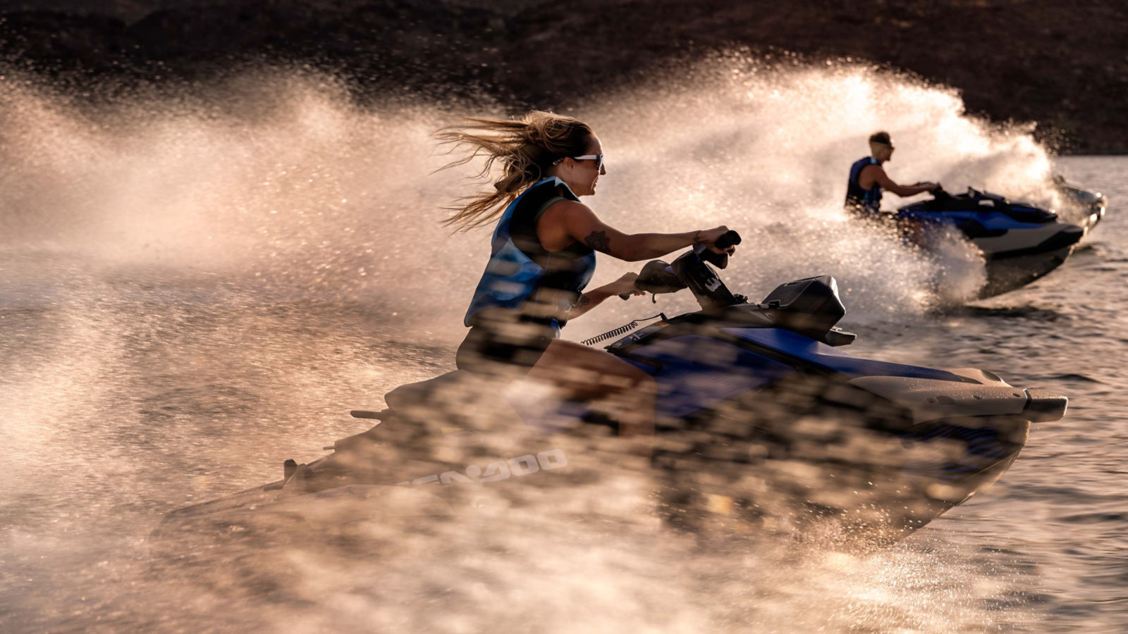 Two persons each riding a 2025 Sea-Doo Spark Trixx personal watercraft