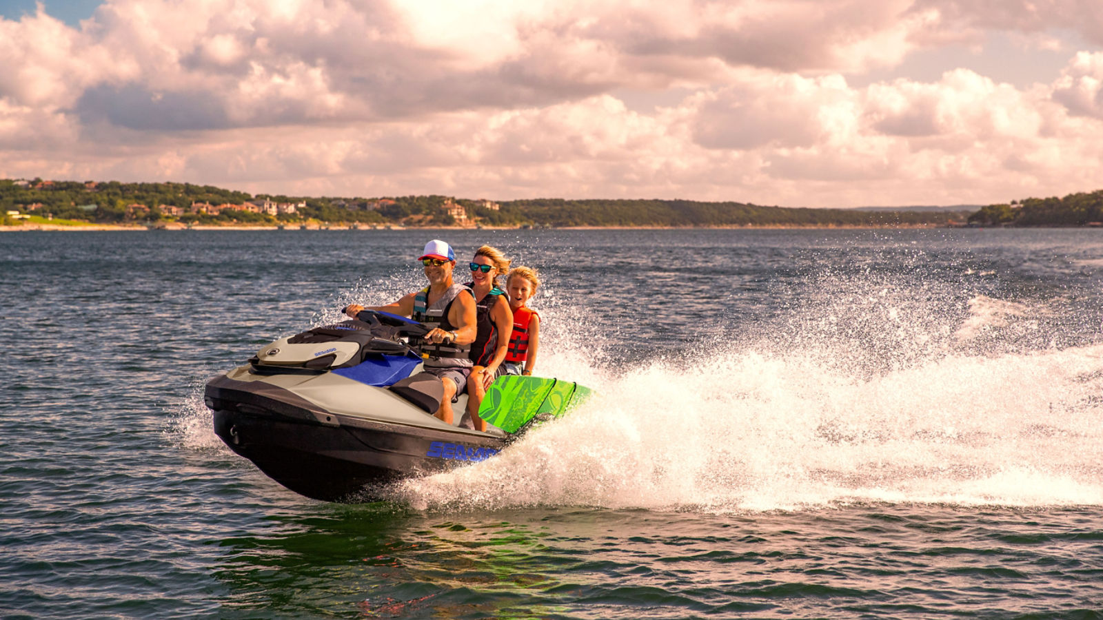 Man, woman and child riding on a Sea-Doo Wake Pro 230 personal watercraft