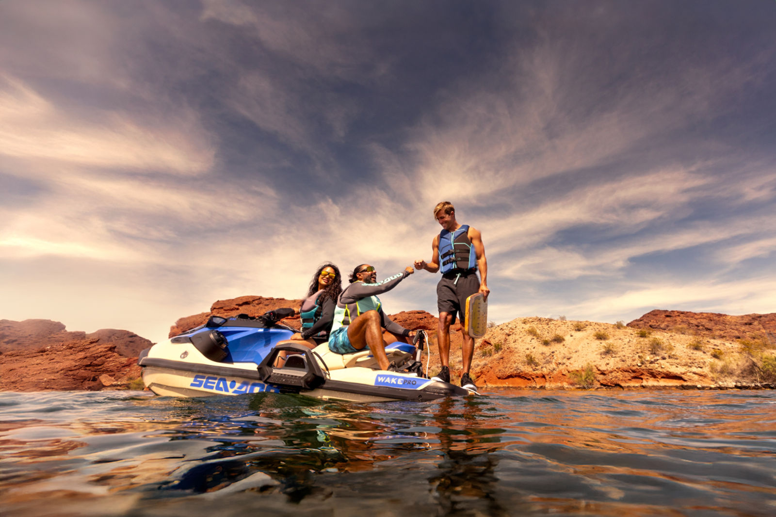 Tres personas conversando en una moto acuática Sea-Doo Wake Pro 2025