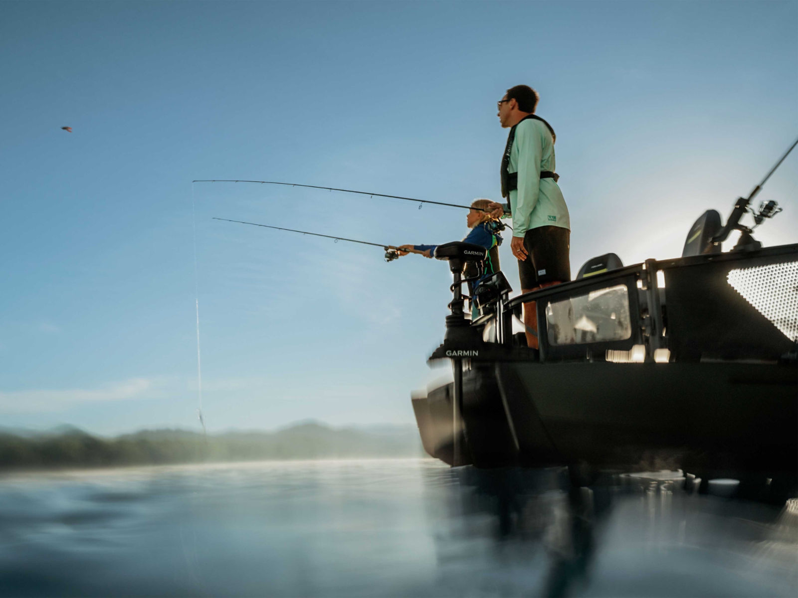 Father and daughter fishing from the 2025 Sea-Doo Switch Fish pontoon boat