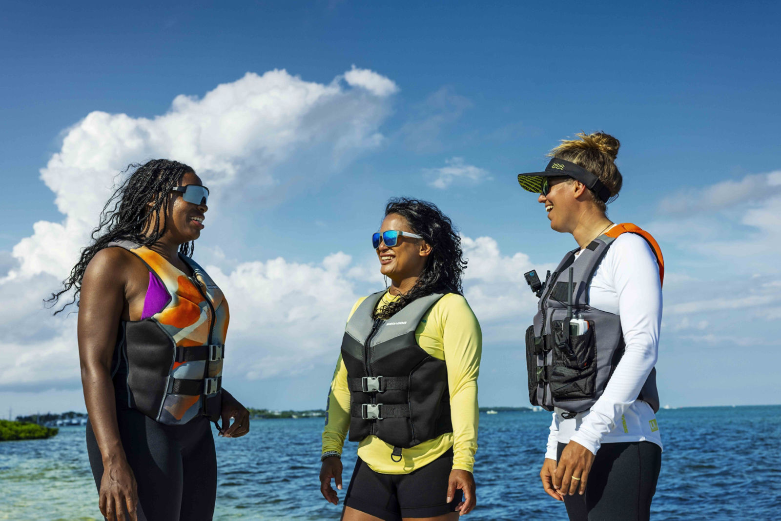 Three smiling women wearing Sea-Doo PFDs