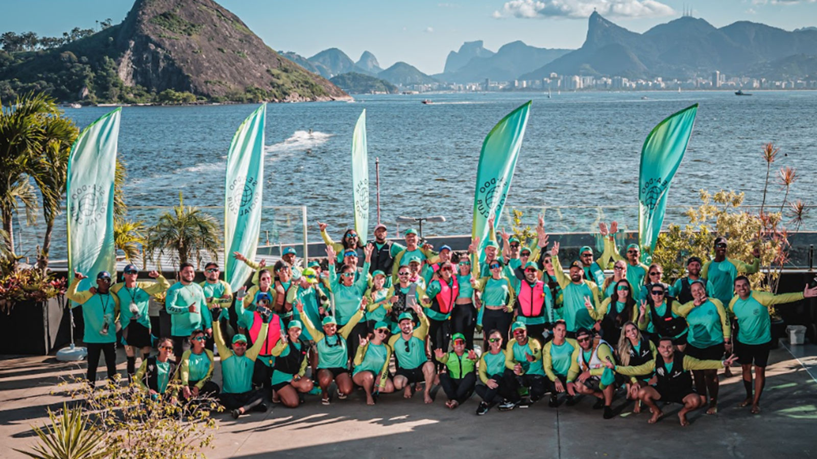 De nombreux membres du club social Sea-Doo prennent une photo devant un magnifique lac et une montagne