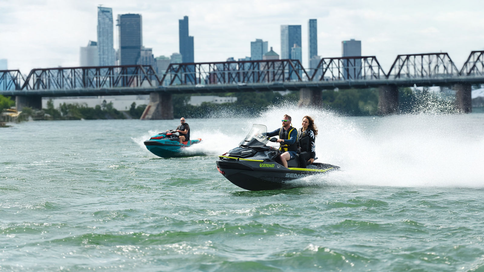 Two personal watercraft traveling at high speed on the water