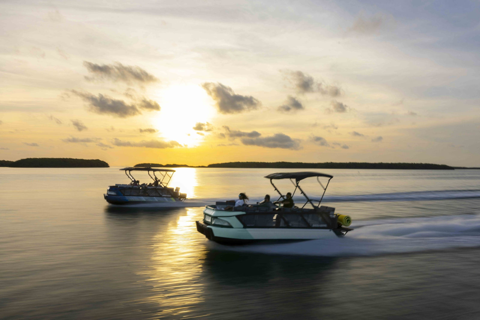 Two Sea-Doo Switch pontoon boats riding on a lake
