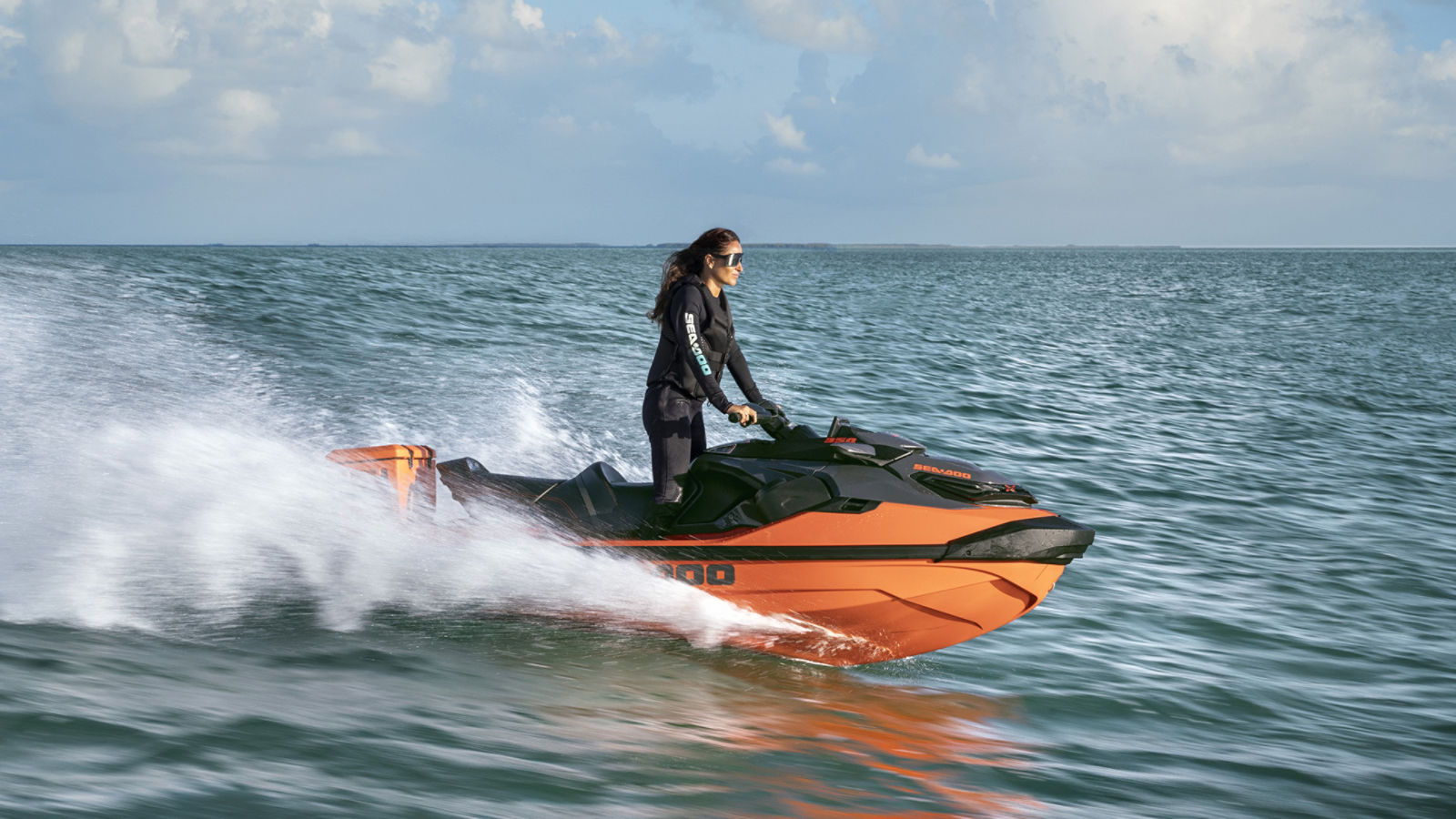 A woman splashing through the water on her 2027 Sea-Doo RXT-X personal watercraft
