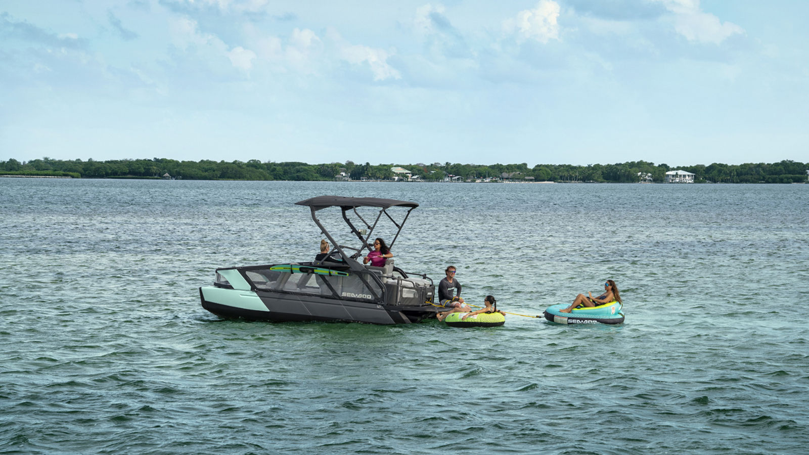 Une famille profitant d'une pause après avoir pratiqué des sports nautiques à bord de leur ponton Sea-Doo Switch Sport 2027