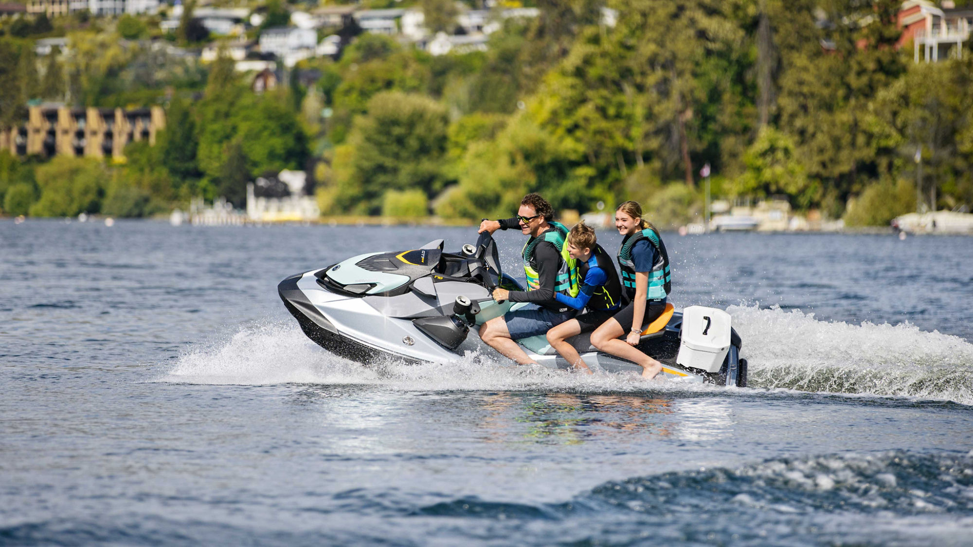 Family riding a Sea-Doo watercraft in the water