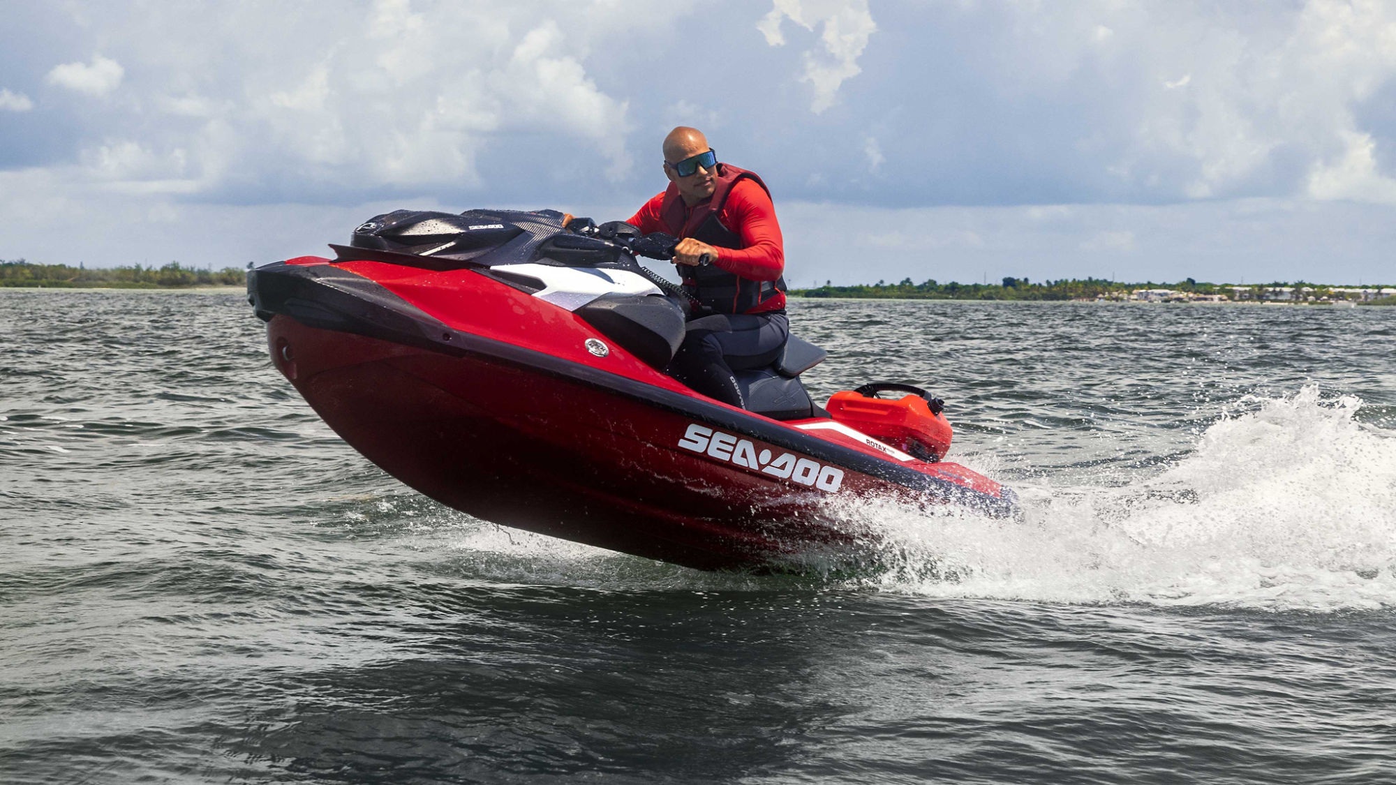 Men jumping a wave with a 2024 Sea-Doo RXP-X equipped with a LinQ fuel caddy