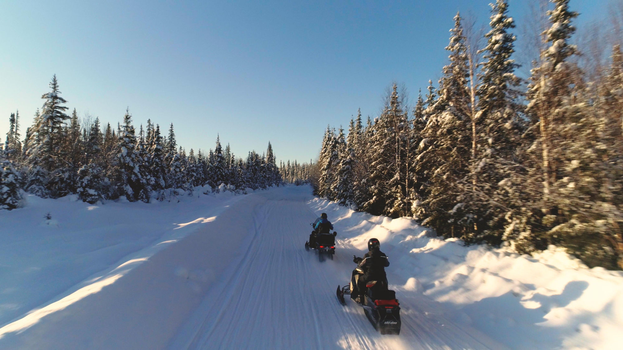 Two snowmobilers in a trail