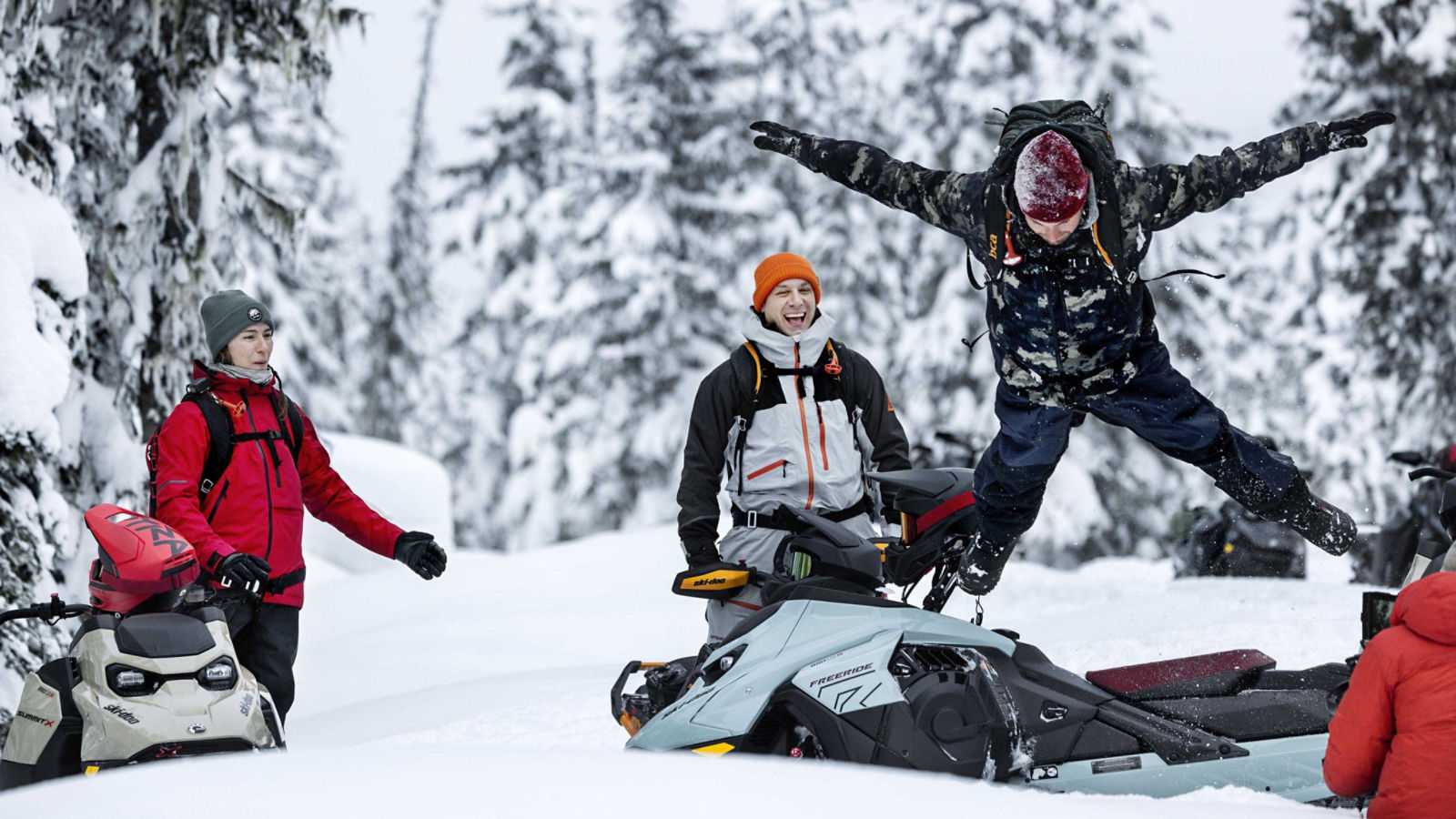 Homme sautant dans la neige avec ses amis riant en arrière