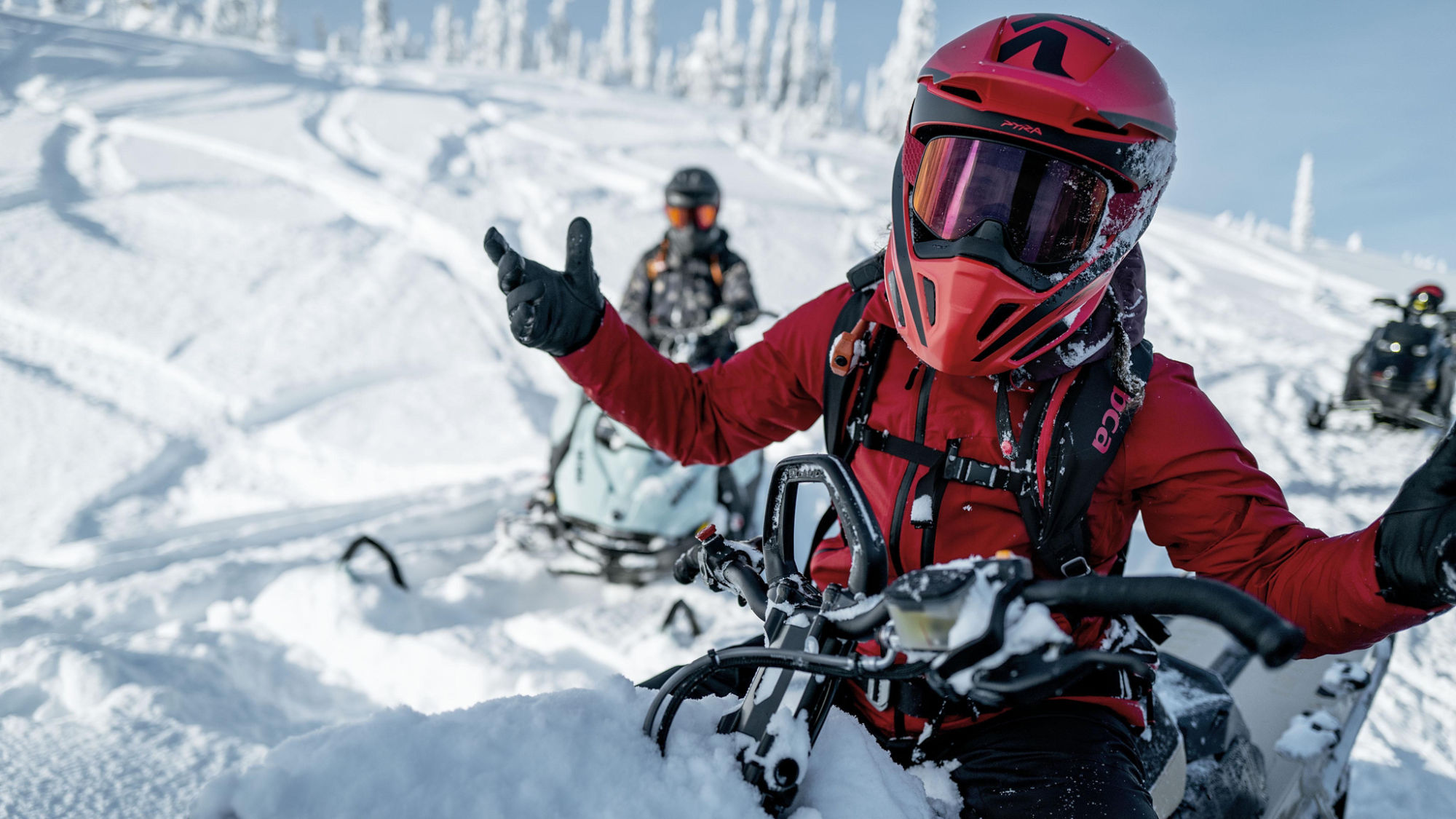 Two riders in the mountains wearing Ski-Doo BC series apparel