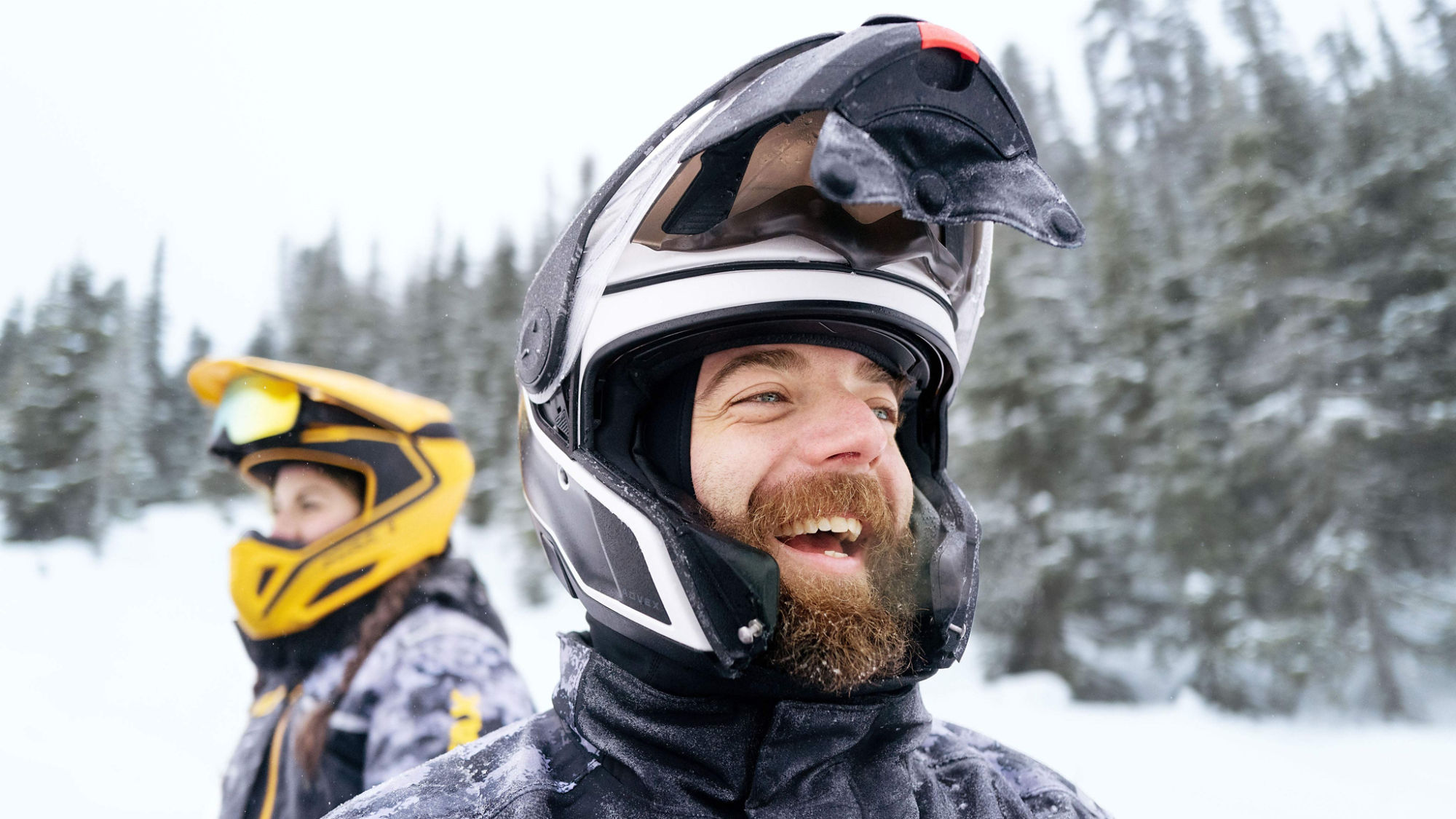 Two riders wearing Ski-Doo trail helmets and apparels