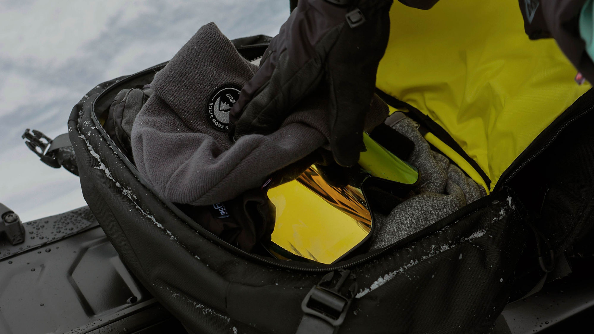 Rider packing items in a LinQ bag on his 2025 Ski-Doo NEO+
