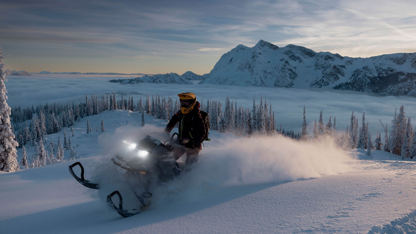 Femme conduisant une motoneige Ski-Doo Summit en montagne