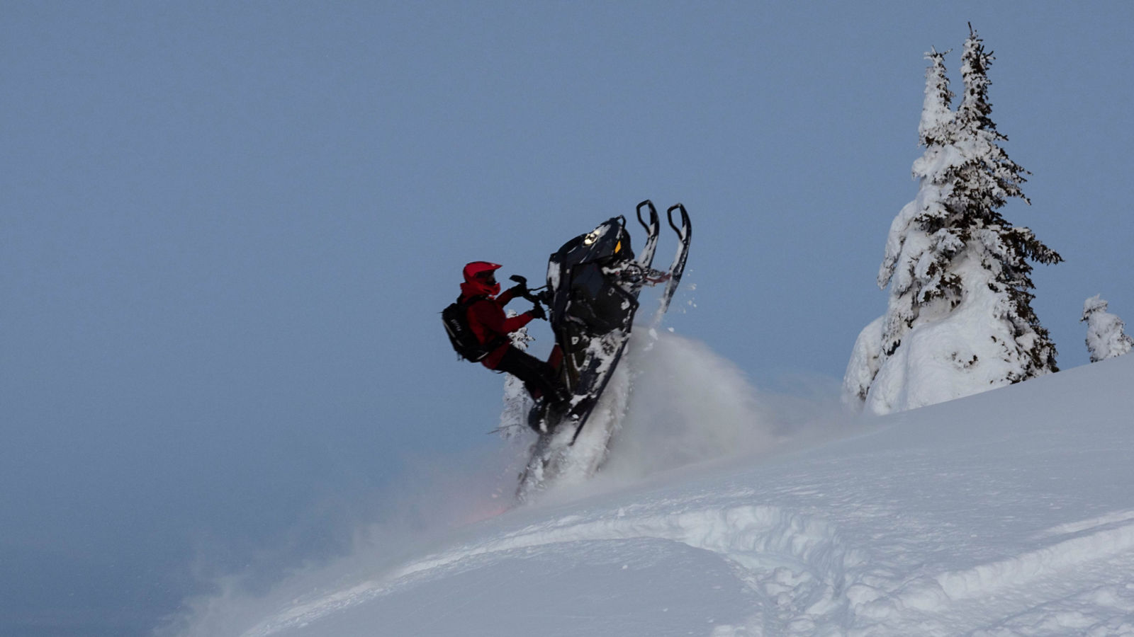 Rider pulling off a jump on a 2025 Ski-Doo Summit deep snow snowmobile
