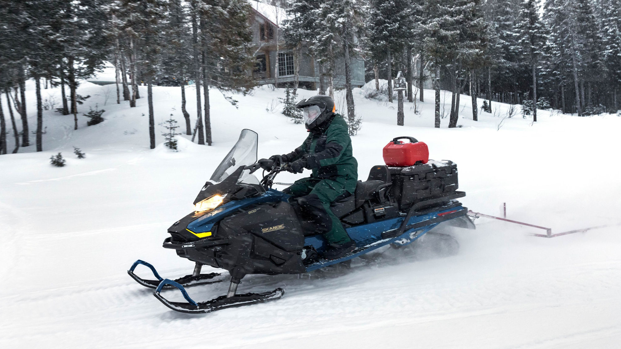 Ski-Doo Skandic SE utility snowmobile riding on a snowy trail