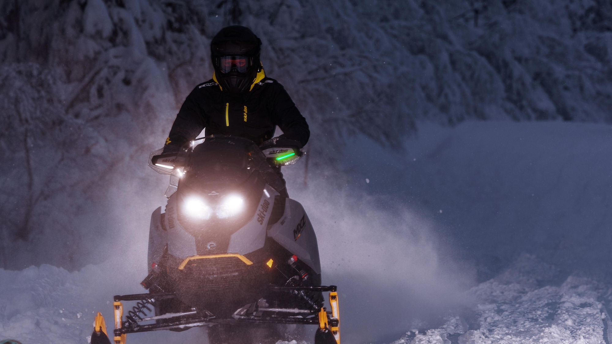 Motoneige Ski-Doo MXZ 2025 en randonnée nocturne dans une forêt enneigée