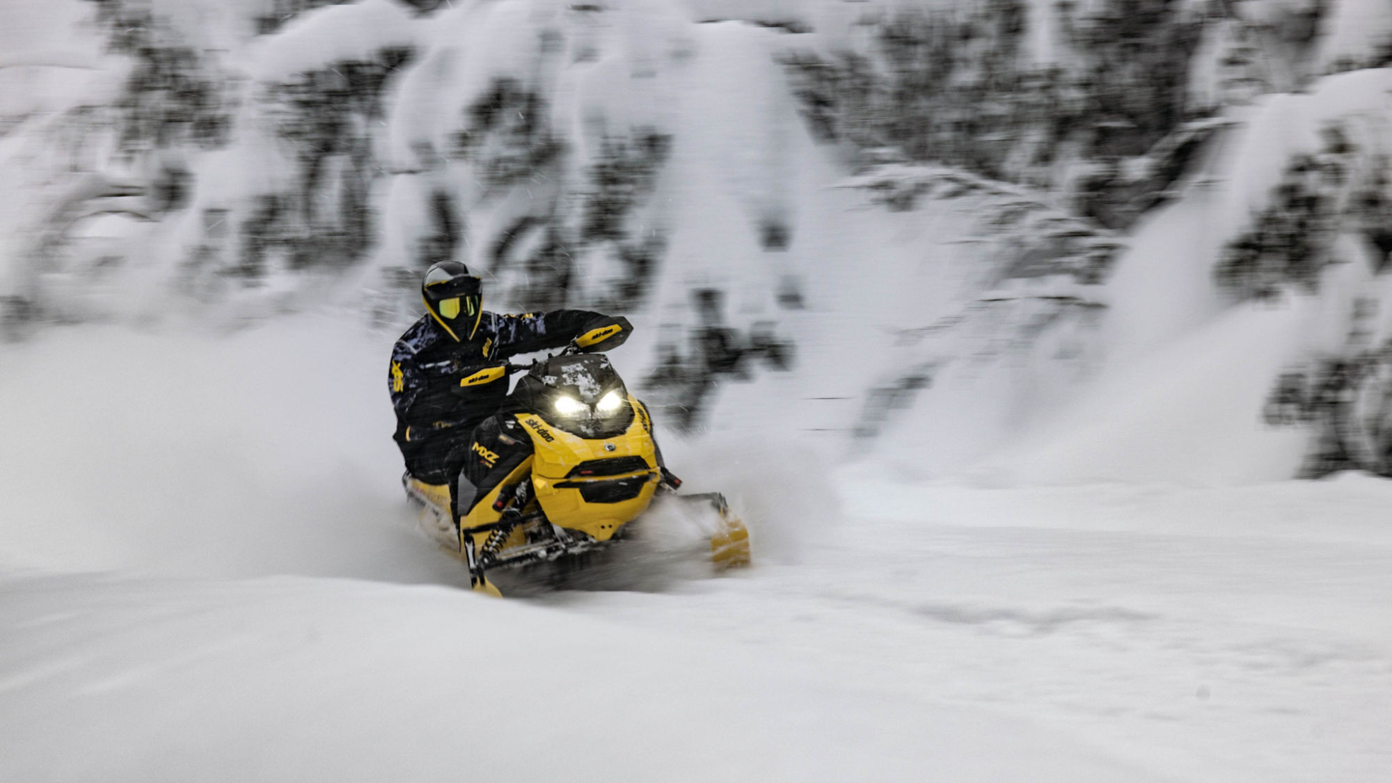 Ski-Doo rider on groomed trails with mountains in the backdrop