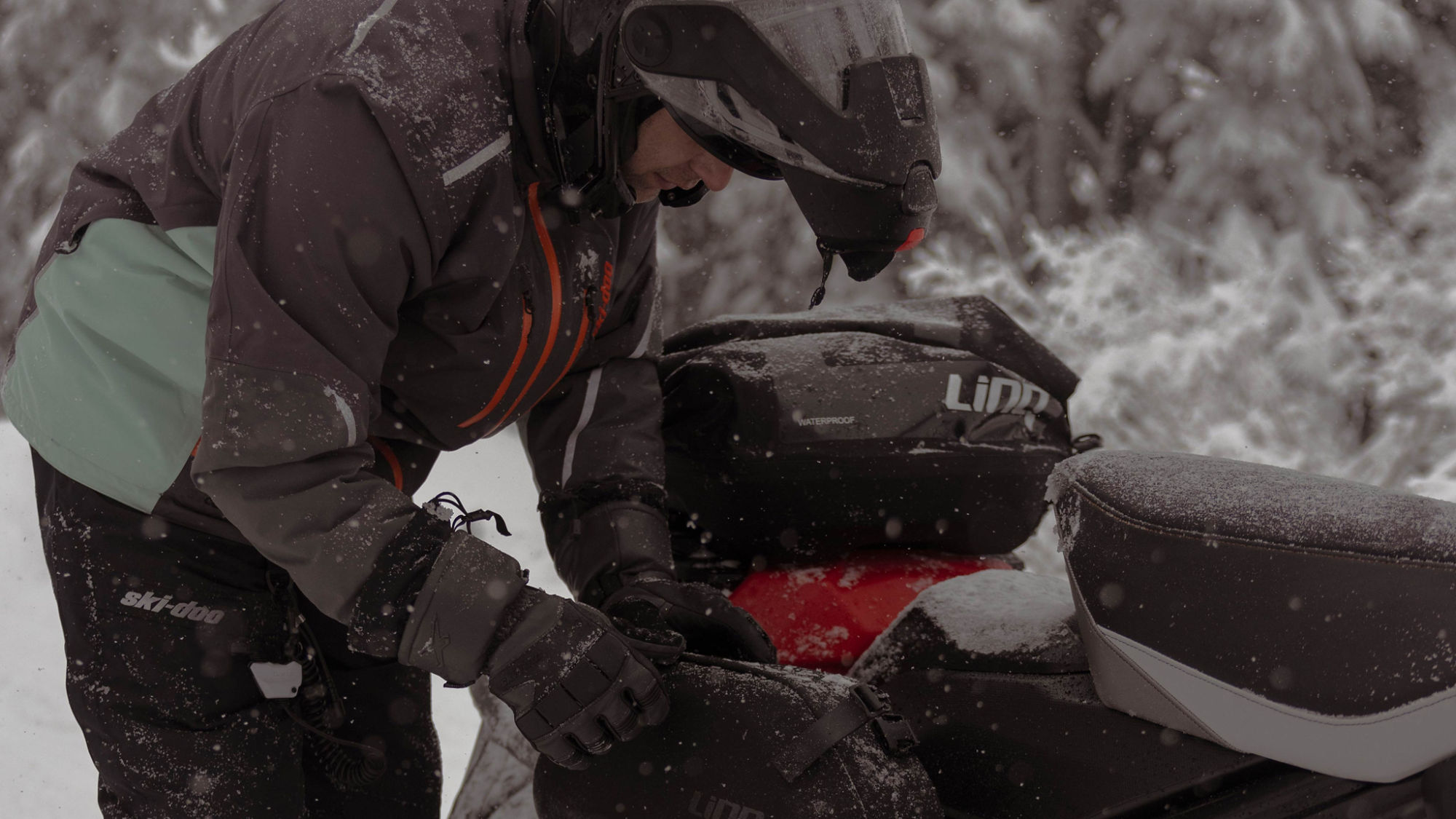 Motoneigiste qui utilise son équipement LinQ sur un Ski-Doo Renegade