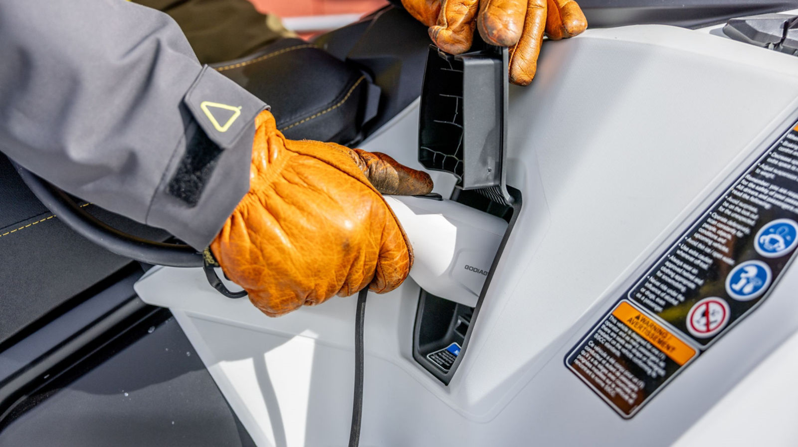 Rider using a charge station to charge his Ski-Doo Electric Snowmobile