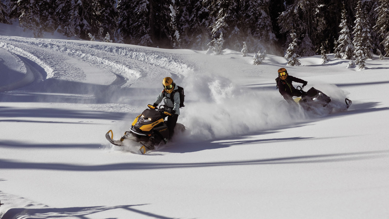 Two 2025 Ski-Doo snowmobiles riding in deeps snow