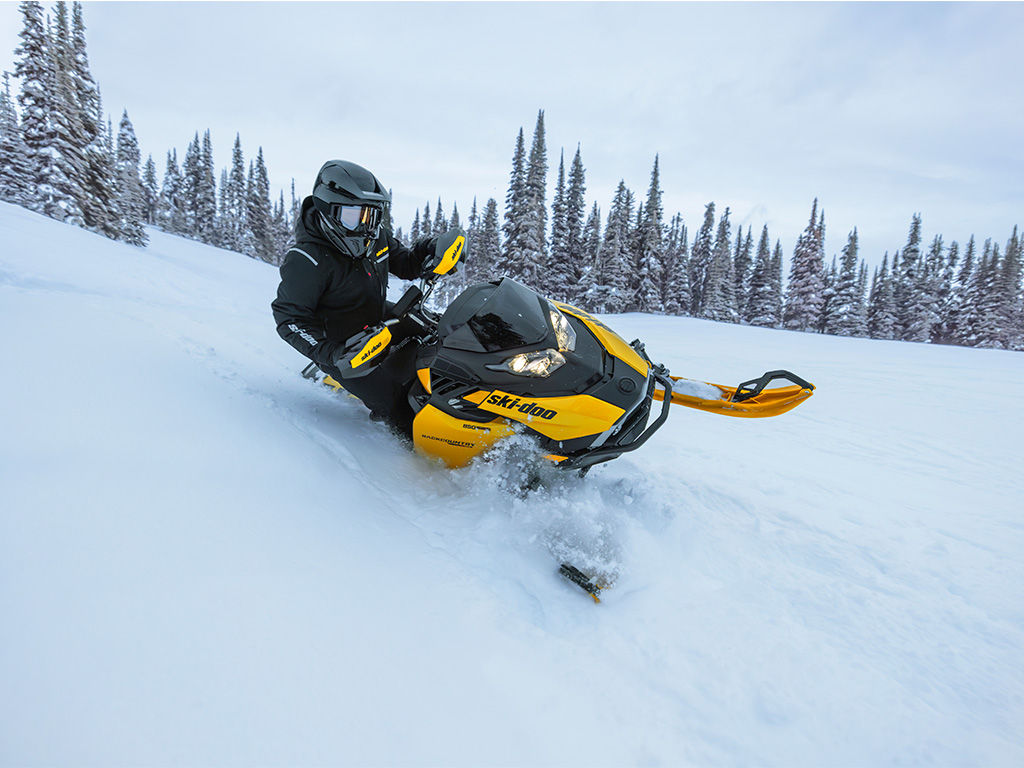 Motoneigiste qui descend une pente enneigée avec un Ski-Doo Backcountry X-RS 2027